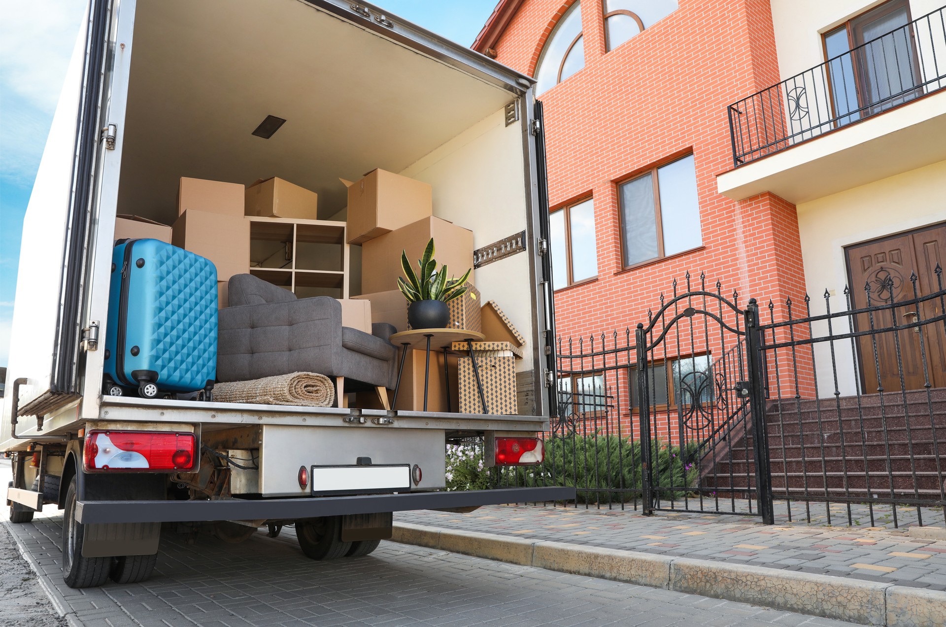 Van full of moving boxes and furniture near house