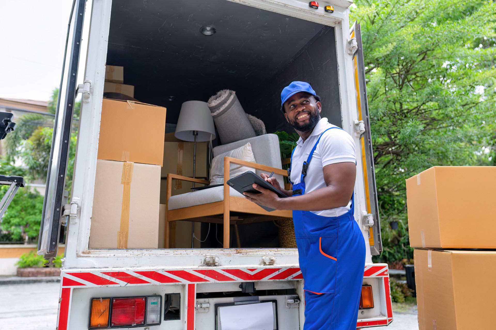 Delivery house move cargo truck service man checking box list from digital tablet for signature