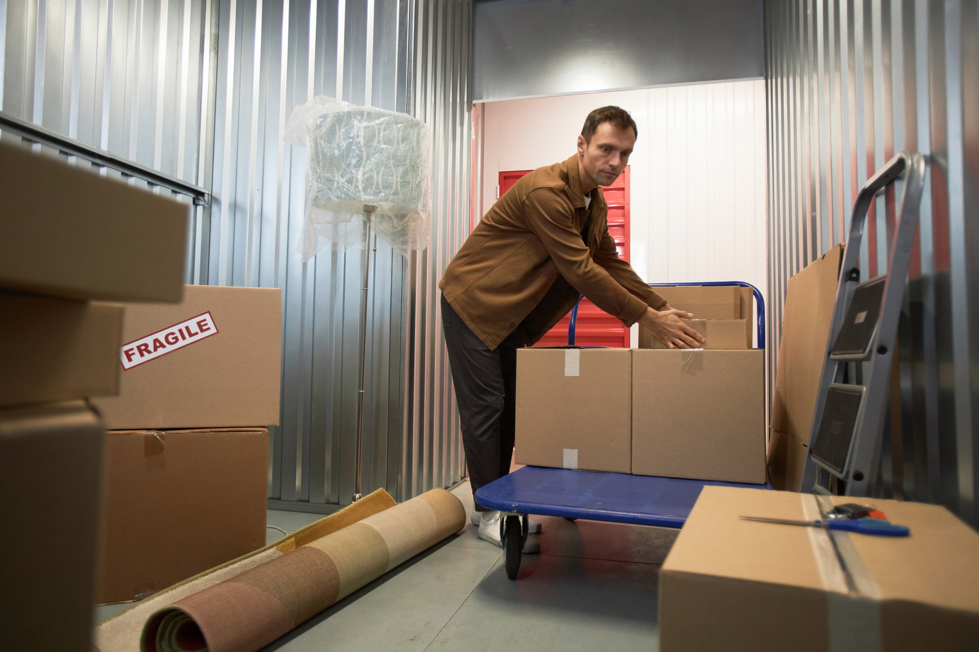 Man Sorting Boxes in Storage Unit